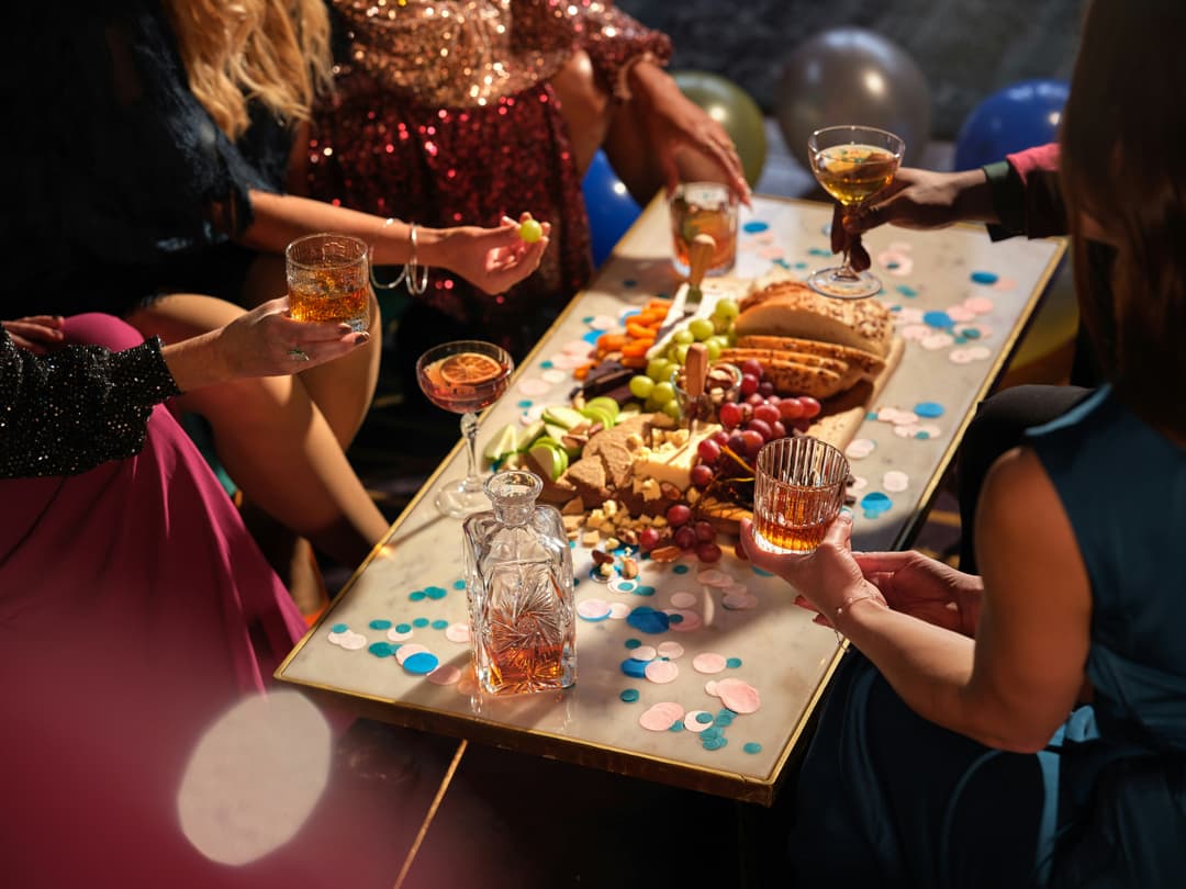 people at a table full of appetizers drinking and having a good time