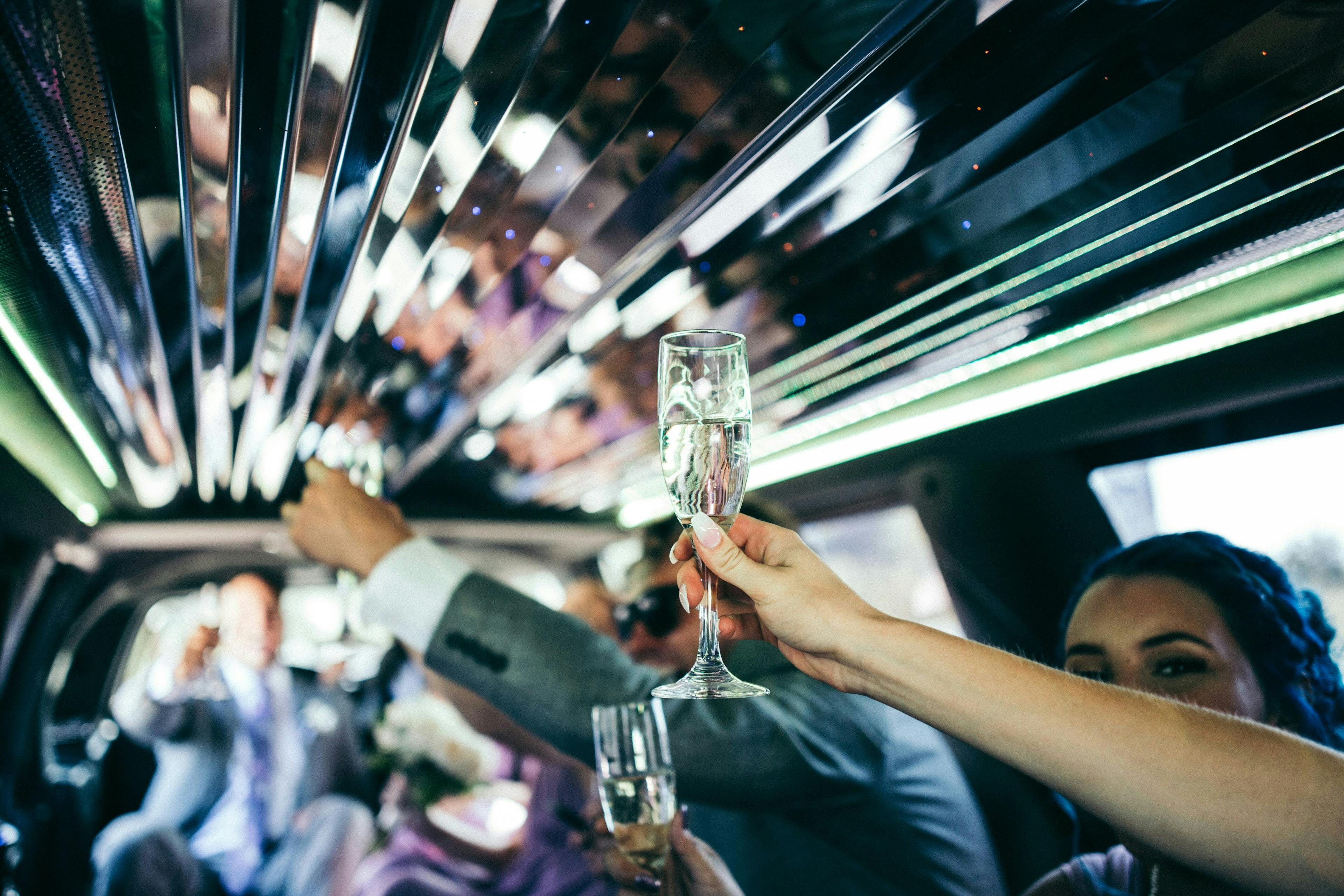 People in a luxury limousine having a good time drinking champagne